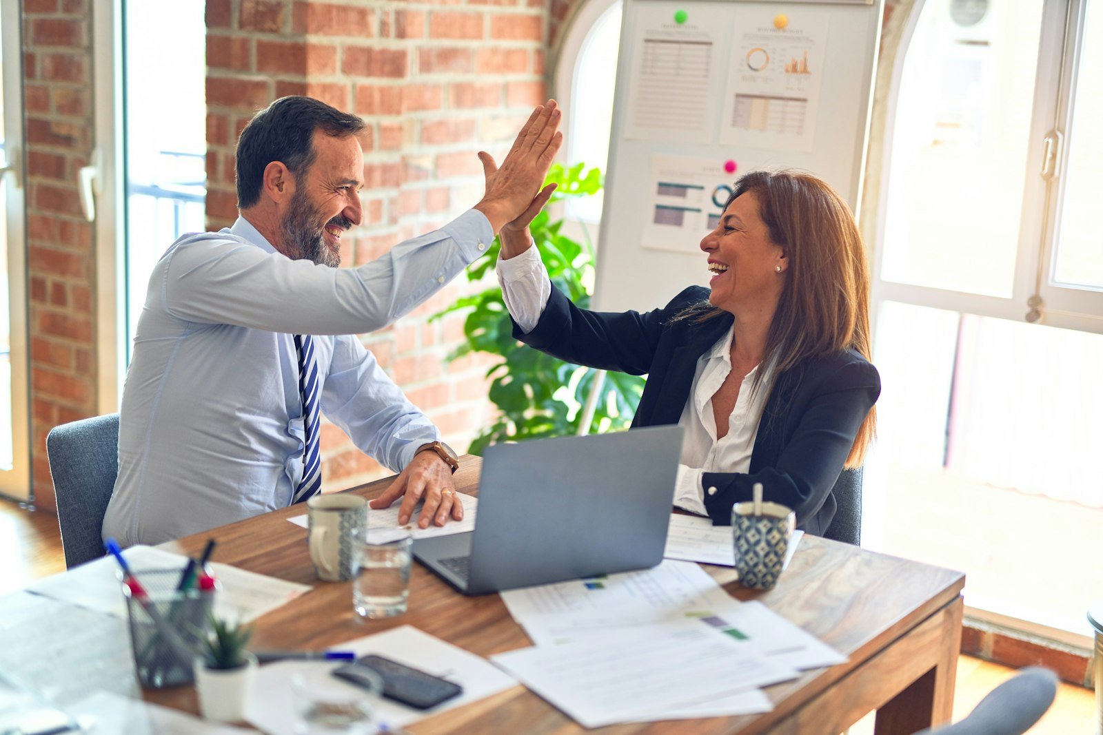 Consultores de CEFEM celebrando un resultado con una empresa cliente en su oficina